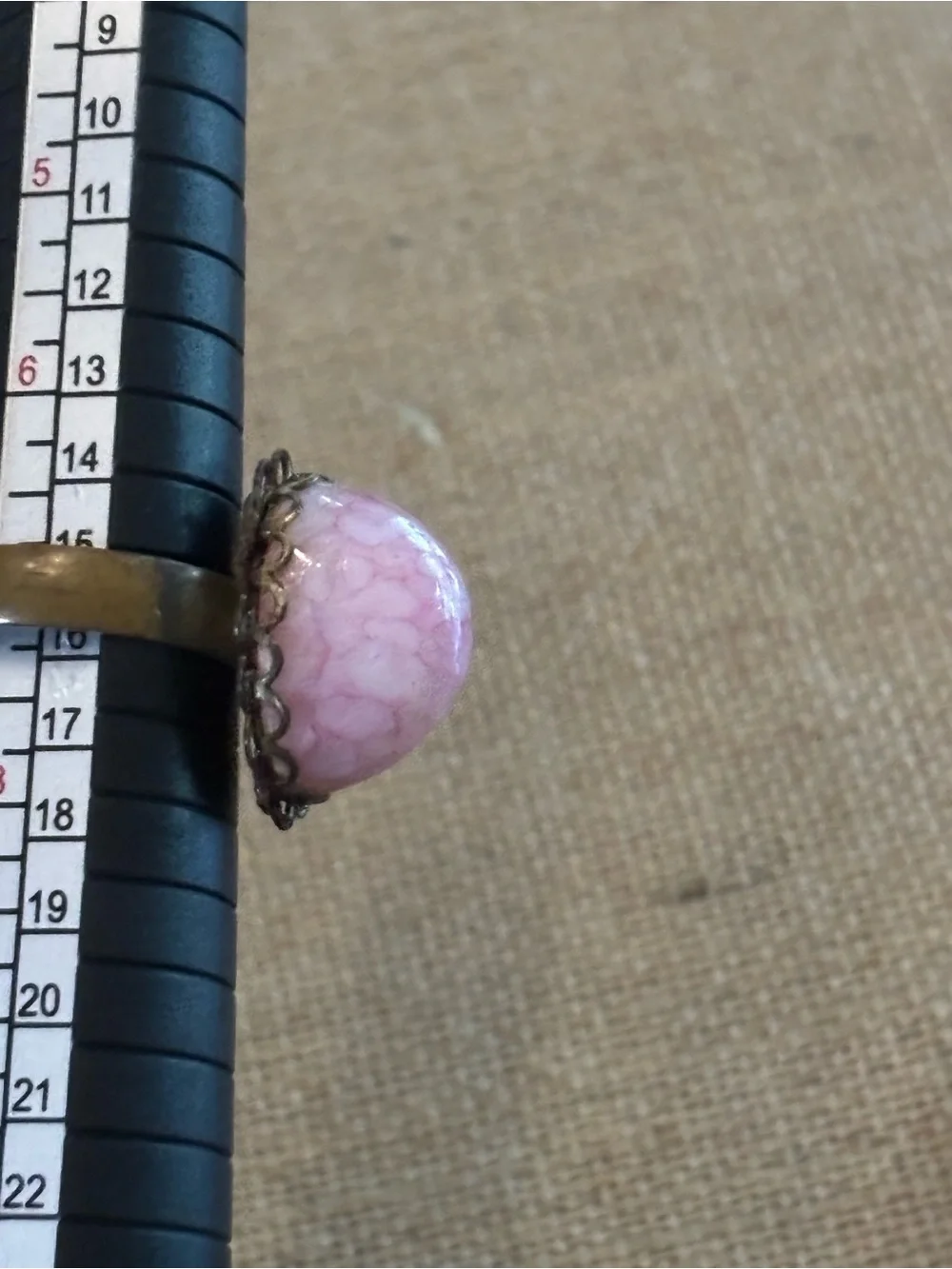 Pink cabochon stone set in an ornate, antiqued brass filigree setting Adjustable